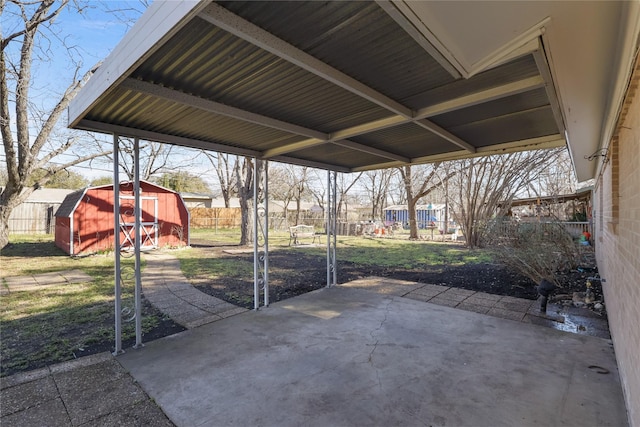 view of patio featuring an outbuilding, fence, and a shed