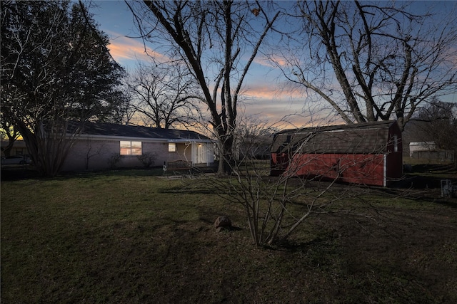 yard at dusk featuring an outbuilding