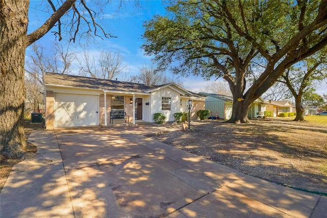 single story home featuring a garage, cooling unit, and driveway