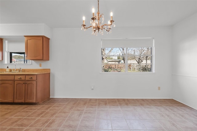 kitchen with brown cabinets, light countertops, a sink, and light tile patterned floors