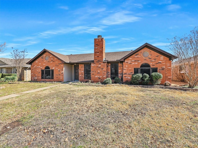 single story home featuring brick siding, a chimney, a front lawn, and roof with shingles