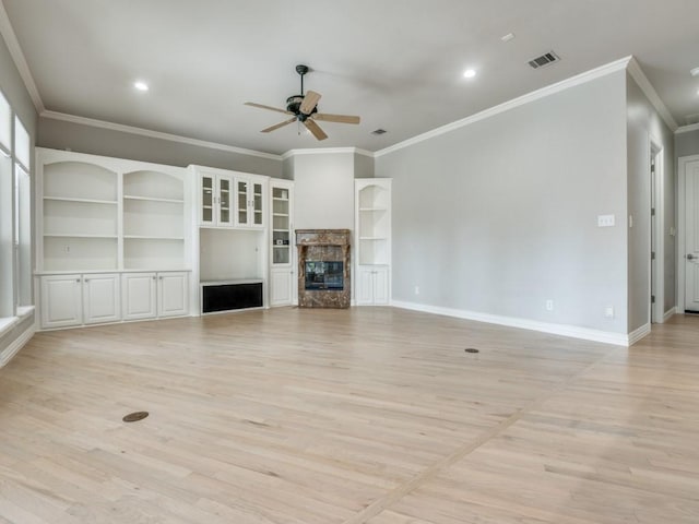 unfurnished living room featuring visible vents, light wood-style flooring, ceiling fan, a stone fireplace, and baseboards