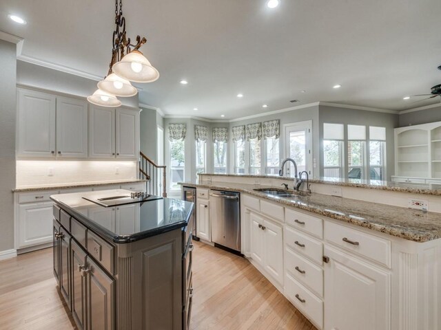 kitchen featuring a center island with sink, dishwasher, light wood-style flooring, black electric cooktop, and a sink