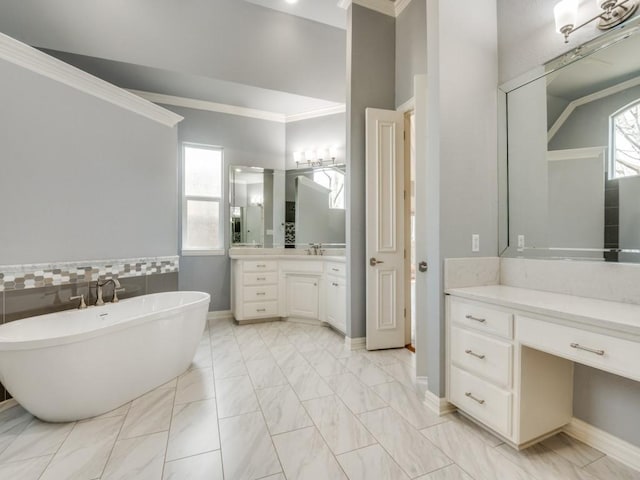 full bath with a soaking tub, marble finish floor, a wealth of natural light, and ornamental molding