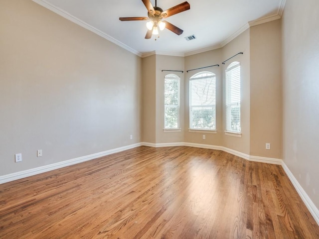 unfurnished room featuring ornamental molding, light wood-style floors, baseboards, and ceiling fan