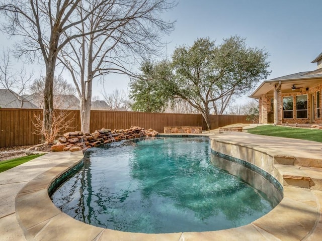 view of swimming pool featuring a fenced backyard, a fenced in pool, and a ceiling fan