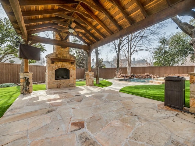 view of patio featuring ceiling fan, an outdoor stone fireplace, a fenced backyard, and a fenced in pool