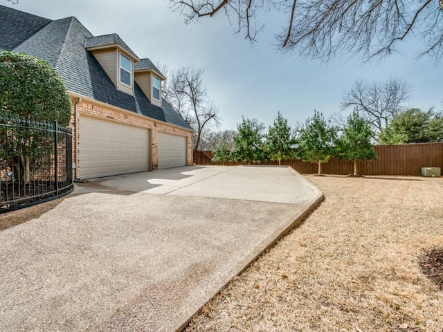 view of yard with a garage, driveway, and fence