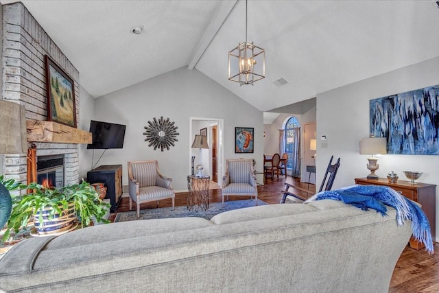 living area featuring a notable chandelier, a fireplace, wood finished floors, visible vents, and beamed ceiling