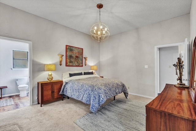 bedroom with baseboards, carpet flooring, ensuite bath, and an inviting chandelier