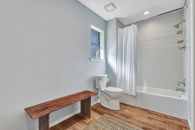 bathroom featuring toilet, shower / bath combination with curtain, baseboards, and wood finished floors