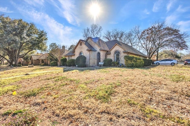 french country inspired facade with a front lawn