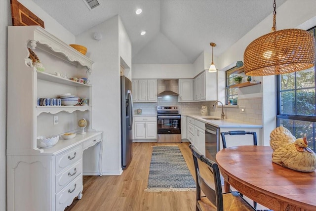 kitchen featuring open shelves, stainless steel appliances, light countertops, a sink, and wall chimney range hood