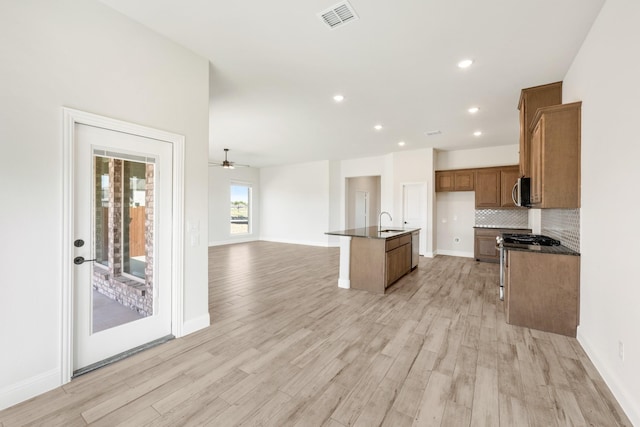 207 Cortese Ln, Alvarado, TX 76009 - kitchen featuring visible vents, open floor plan, appliances with stainless steel finishes, brown cabinets, and light wood-style flooring