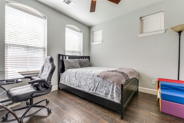 bedroom featuring a ceiling fan, visible vents, baseboards, and wood finished floors