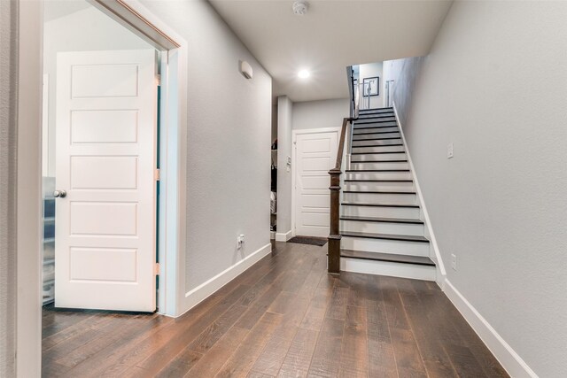 staircase featuring baseboards and wood finished floors