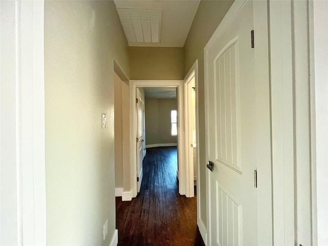 hall with dark wood-type flooring and baseboards