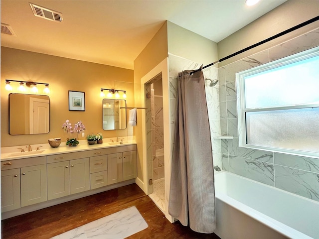 full bath with wood finished floors, a sink, and visible vents