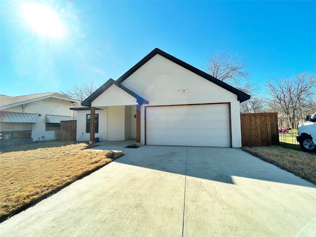 ranch-style home featuring a garage, concrete driveway, brick siding, and fence