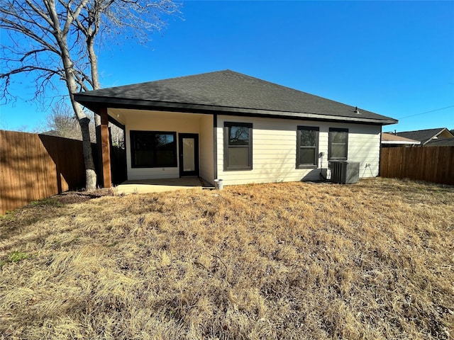 back of property featuring a shingled roof, cooling unit, a patio area, and a fenced backyard