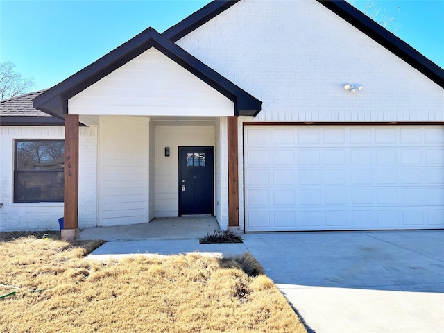 ranch-style house featuring a garage, concrete driveway, and brick siding