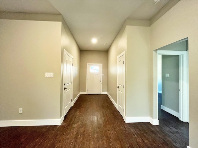 doorway with dark wood-style floors and baseboards