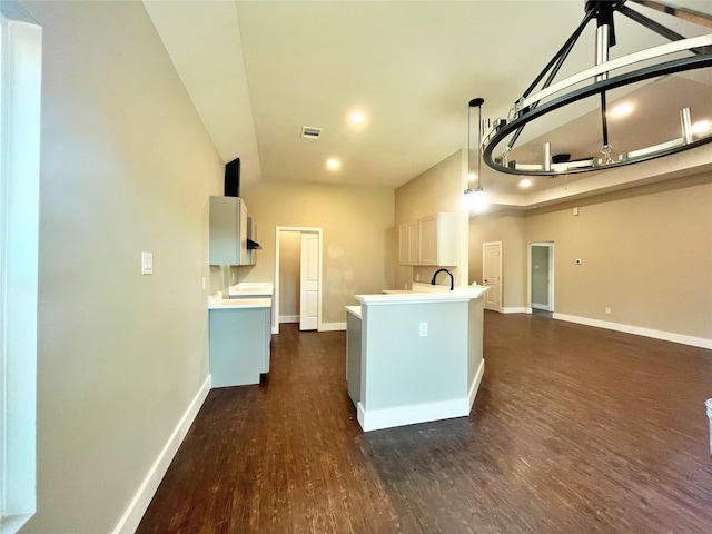 kitchen with light countertops, dark wood finished floors, visible vents, and baseboards