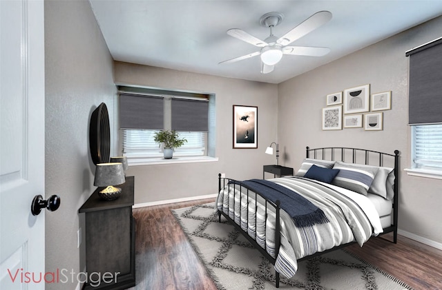 bedroom featuring multiple windows, wood finished floors, and baseboards