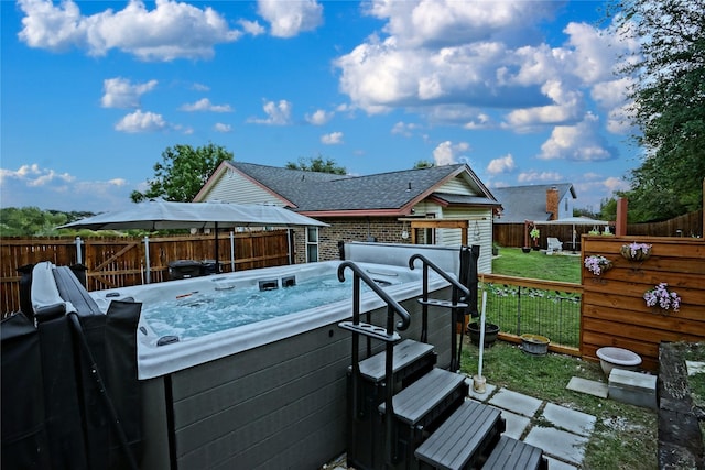 wooden deck featuring a hot tub, a fenced backyard, and a yard