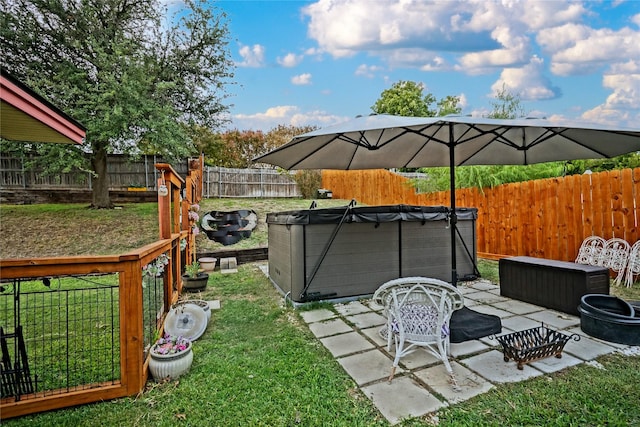 view of yard featuring a hot tub, a fenced backyard, and a patio