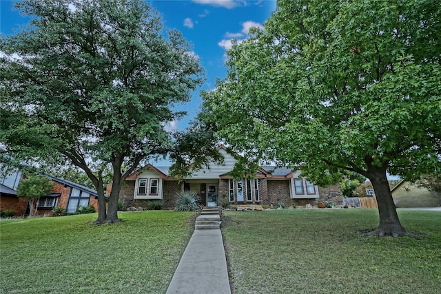 view of front of property featuring a front lawn and brick siding