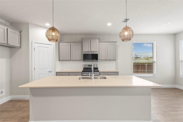 kitchen with gray cabinets, visible vents, stainless steel appliances, and a sink