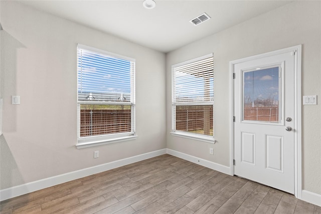 entryway with wood finished floors, visible vents, and baseboards