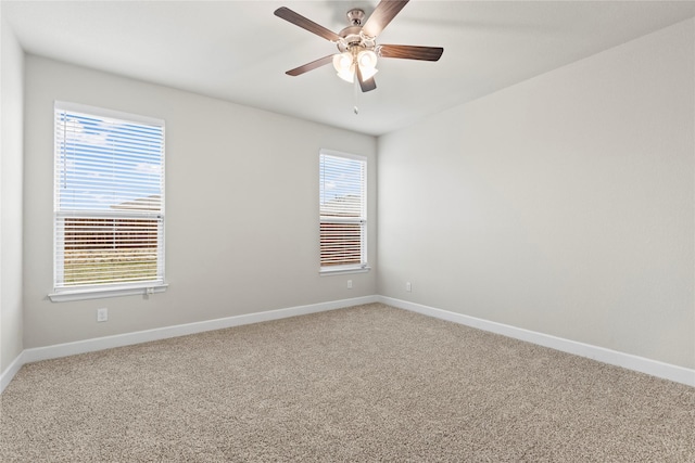 spare room featuring a healthy amount of sunlight, baseboards, a ceiling fan, and light colored carpet