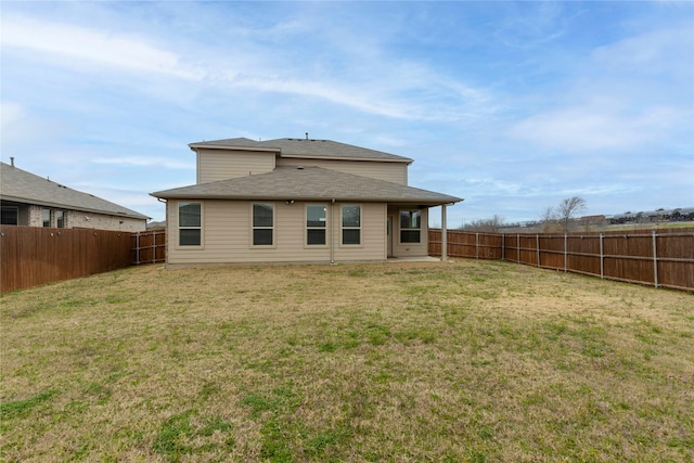 back of property featuring a fenced backyard and a lawn