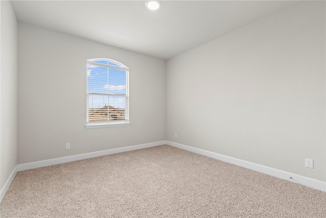 spare room featuring carpet and baseboards