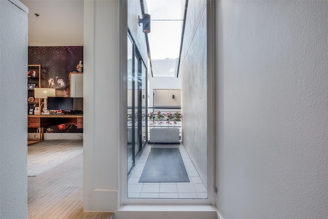 doorway to outside with a textured wall and wood finished floors