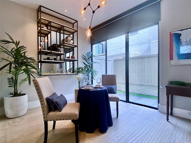 interior space with a notable chandelier, wood finished floors, and baseboards