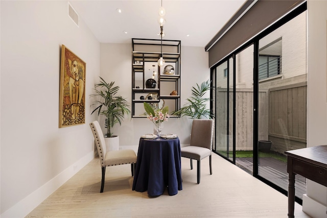 dining area with a wealth of natural light, baseboards, visible vents, and wood finished floors