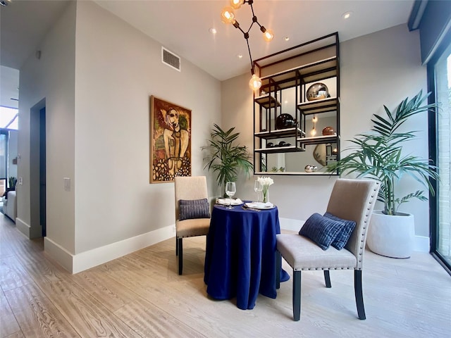 sitting room with an inviting chandelier, baseboards, visible vents, and wood finished floors