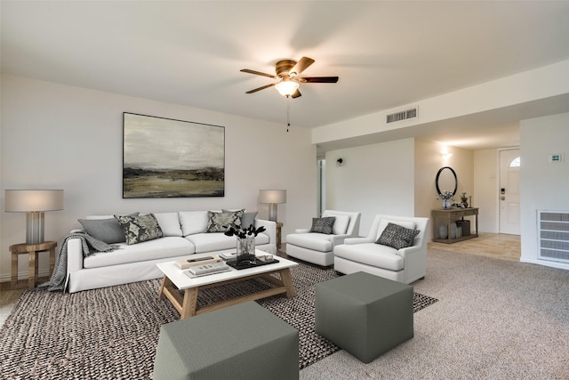 living area featuring carpet floors, baseboards, visible vents, and a ceiling fan