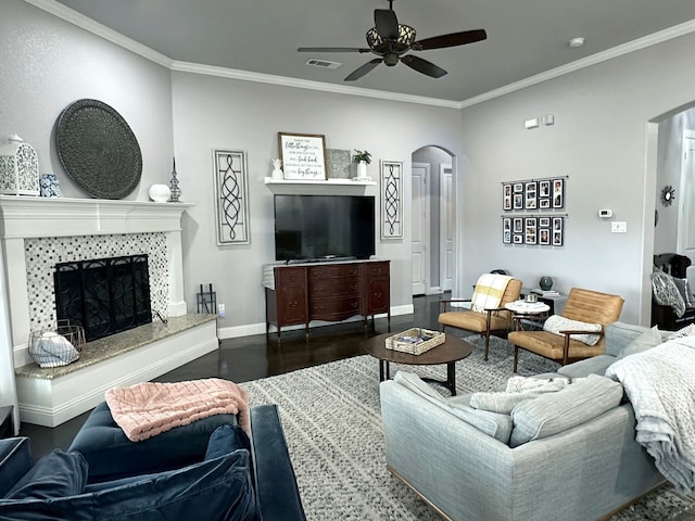 living area featuring arched walkways, ornamental molding, wood finished floors, and visible vents