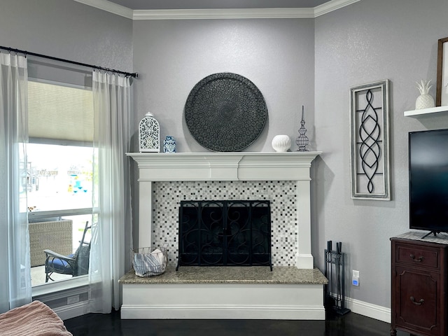 details featuring a tile fireplace, crown molding, and baseboards