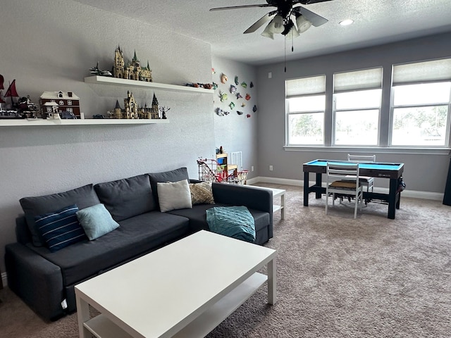 carpeted living room featuring ceiling fan, a textured ceiling, and baseboards