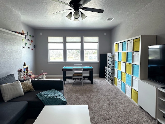 carpeted living room with a textured ceiling, a textured wall, visible vents, and baseboards