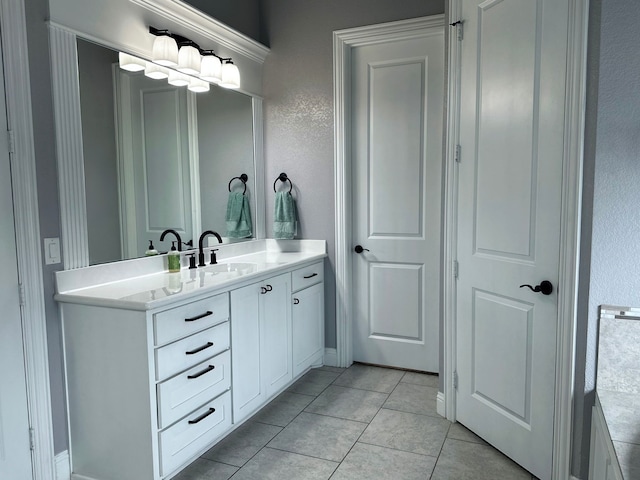 bathroom with tile patterned floors, baseboards, a textured wall, and vanity