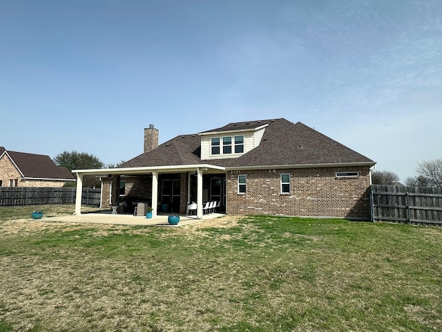 rear view of house featuring brick siding, a patio, and a fenced backyard