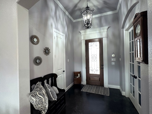 foyer featuring a notable chandelier, crown molding, and baseboards