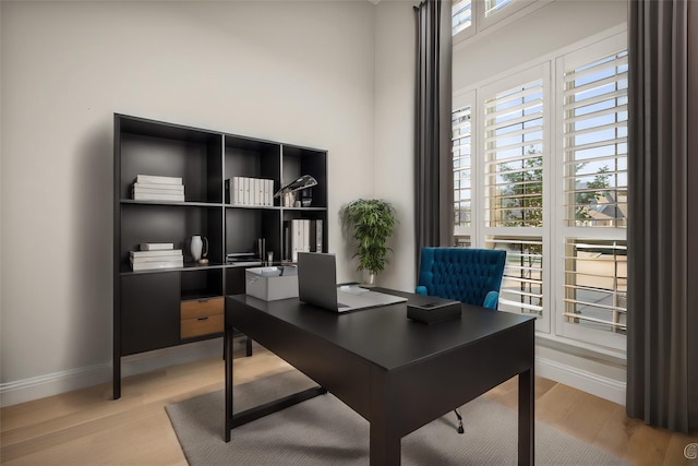 office featuring baseboards and light wood finished floors