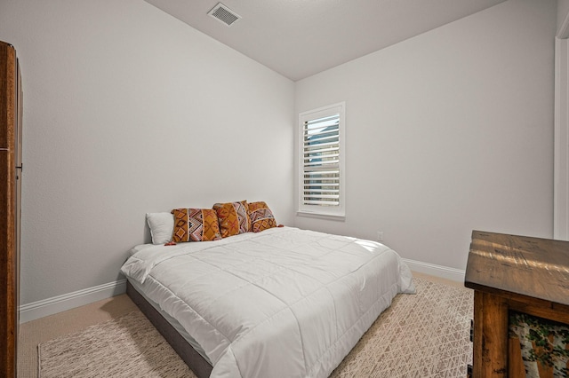 carpeted bedroom featuring baseboards and visible vents